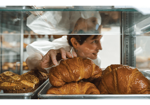 Empire Baking owner, Meaders Ozarow grabbing a croissant for a customer.