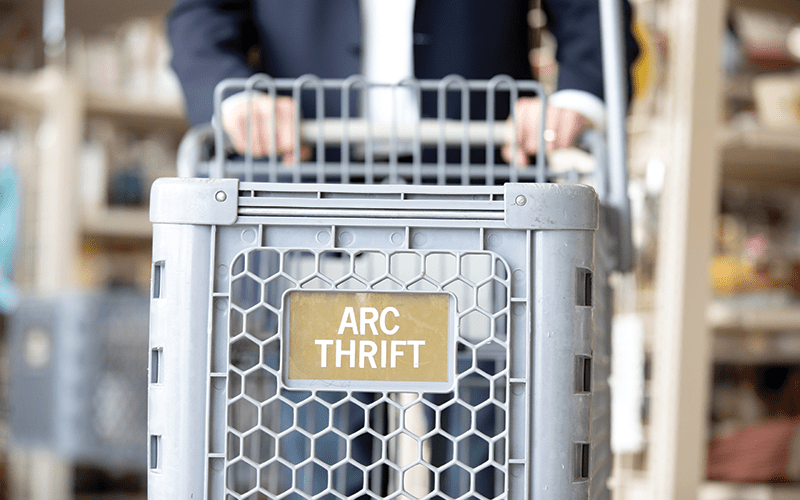 arc Thrift Store grocery cart with logo. 